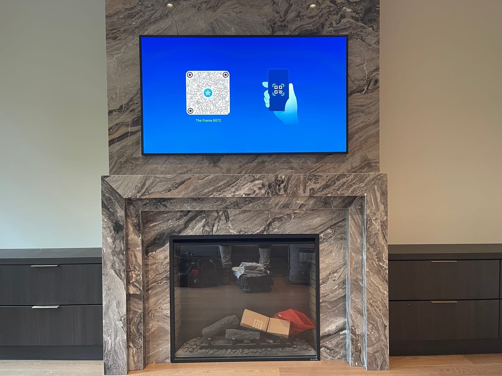 Wall-mounted TV on a stone fireplace feature wall